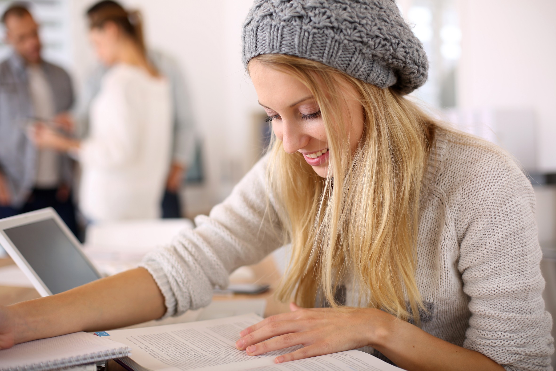 Junge Dame beim Lesen eines Lehrbuchs. Symbol für Berufsunfähigkeitsversicherung für Auszubildende und dual Studierende