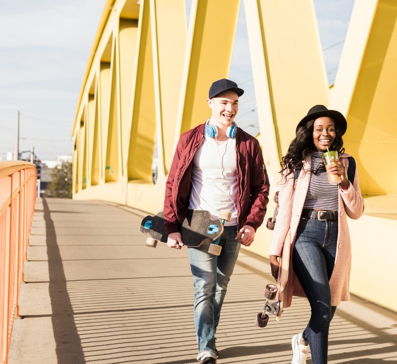 Junge Frau und junger Mann mit Skateboard unter dem Ar; Symbol für Altersvorsorgereform
